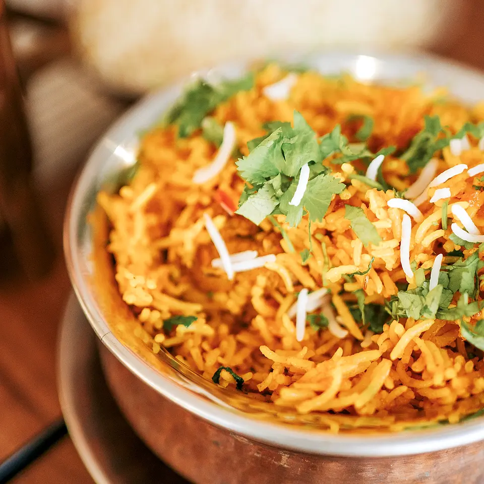 Chicken biryani em taça de cobre com coco